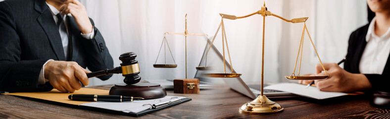 Justice and law concept.Male judge in a courtroom with the gavel, working with, computer and...