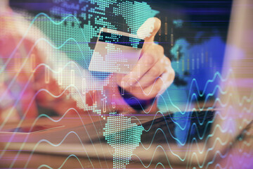 Double exposure of man hands holding a credit card and Forex graph drawing. Stock trading and digital fintech in Internet E-commerce concept.