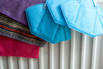 Face mask and kitchen towels dry on the battery.