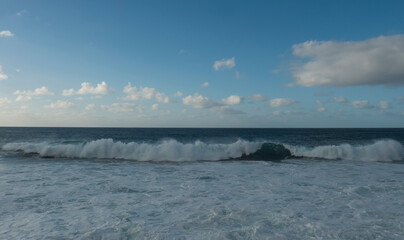 Big breaking waves splash with foam and blue sky, white clouds at atlantic ocean, Gran Canaria, Canary Islands of Spain