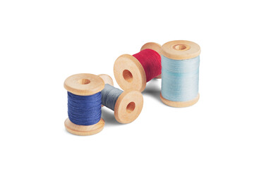 Sewing needle and colorful sewing thread on wooden spool on isolated white background