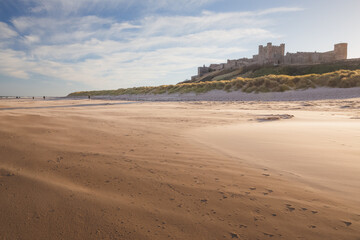 View of the historic Bamburgh Castle from the sandy windswept Banmburgh Beach on the northeast coast of England, Northumberland.