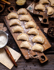 homemade raw dumplings on wooden board. traditional ukrainian food. overhead shot