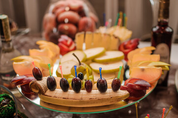 Fruit slicing at a wedding banquet. Watermelon, grapes, strawberry, orange, plum, pear, dinha, peach, kiwi, pineapple, persimmon, apple