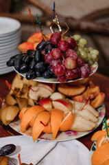 Fruit slicing at a wedding banquet. Watermelon, grapes, strawberry, orange, plum, pear, dinha, peach, kiwi, pineapple, persimmon, apple
