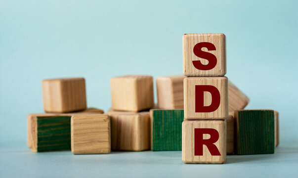 SDR - acronym on wooden cubes on a background of colored block on a light background