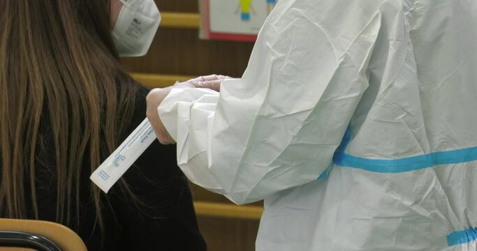 A doctor in a protective suit taking a nasal swab to test for possible coronavirus infection Covid-19 Pandemic Concept
