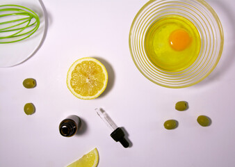 Cosmetic product. Natural ingredients for the preparation of the hair mask: lemon, eggs, olive oil, hairbrush and whisk for stirring. Hair and skin care mask