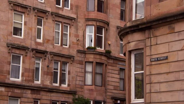 Lockdown shot of brown residential buildings with White Street sign on wall in city - Glasglow, Scotland