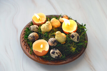 Easter composition - plate with moss, Easter eggs and diy candles in eggs shells, chickens. symbol Ostara or Easter holiday. festive spring season. wicca pagan tradition