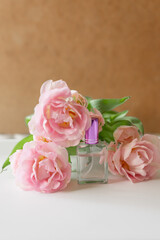 Composition from jars of perfumery with spring flowers, pink tulips on a white background. Beautiful background, mockup for perfumery.