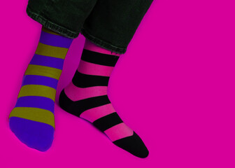 Legs with different stripes socks on background with copy space. World Down syndrome day background. Down syndrome awareness concept.