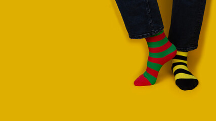 Legs with different stripes socks on background with copy space. World Down syndrome day...