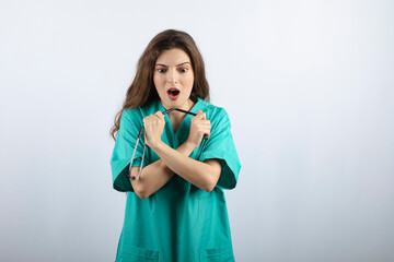 Young beautiful nurse in green uniform holding stethoscope