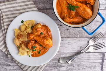 Paprika chicken with dumplings in plate and pan spot