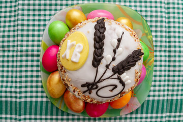 Easter cake and Easter bright colored eggs are on the plate