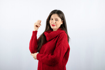Portrait photo of a young woman model in red warm sweater standing and posing