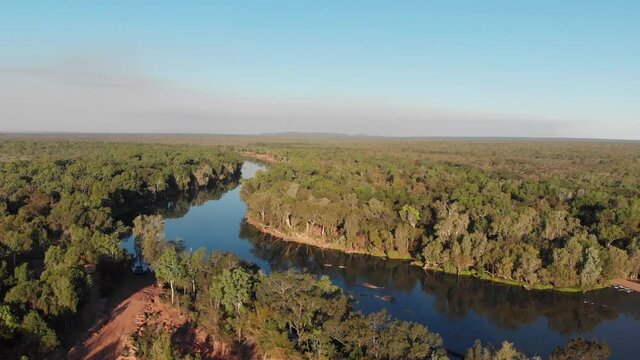Aerial view left to right of a curvy river in the middle of lush forest, Australian outback, Darwin, Australia