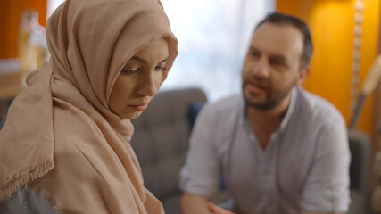 While the sad Muslim woman wearing a headscarf is looking sad with her eyes and she continues to...