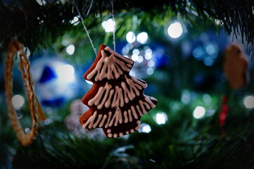 Beautiful decorated gingerbread in a shape of a tree hanging on a Christmas tree