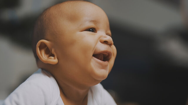 Portrait of adorable african american black baby. Baby laughing while having tummy time. High quality photo
