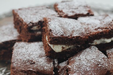 Macro food photography of chocolate cake brownies with cream filing stacked 