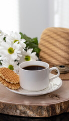 Fototapeta na wymiar White cup with black coffee. Morning coffee, breakfast, cookies, tropical leaf, wicker hat. Summer sunny background. Breakfast on vacation at the hotel. Traveling at sea, close-up.