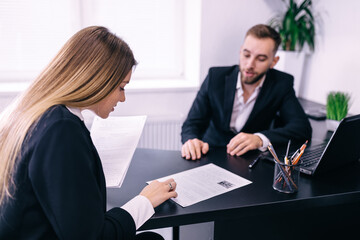 Successful teamwork: business man and woman sitting at desk talk