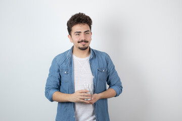 Photo of a smiling attractive man standing and holding a glass jar