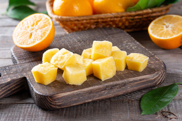 Frozen Lemon Juice cubes on a wooden table, closeup