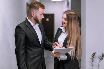 boss and young subordinate talking standing in office hallway, u