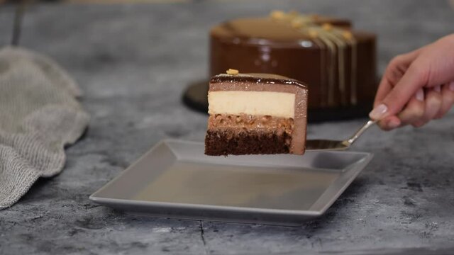 Piece of chocolate caramel peanut mousse cake, snickers on a plate.