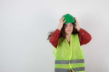 Image of a young cute girl standing in vest and wearing a crash helmet