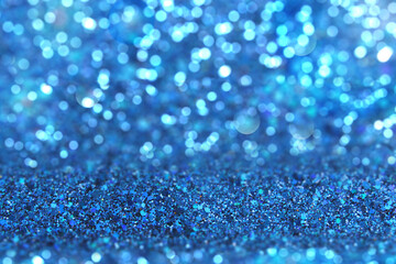 Shiny background. Beautiful glowing bokeh. Bright glowing background. Shiny glowing effect. Blue sequins.