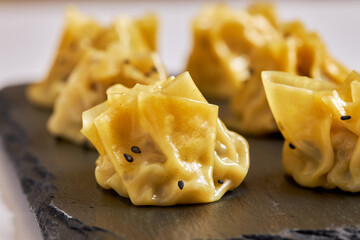 Close-up of prawn siu mai on black plate.