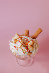 Delicate creamy dessert in a glass on a pink background.