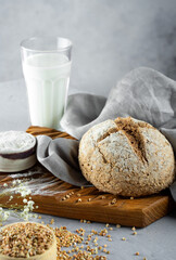 Homemade loaf of freshly baked green buckwheat bread and organic buckwheat milk. Wooden, linen napkin. Harmless,wellness, gluten free healthy baking for vegans. Alternative bread and vegetarian milk