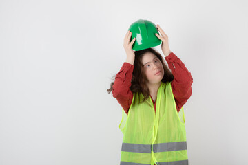 Image of a young cute girl standing in vest and wearing a crash helmet