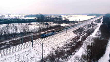 Winter scenery. Train dashing through the snow covered railroad. aerial view. High quality photo