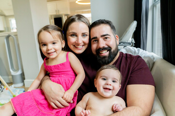Portrait of happy family hugging in their home