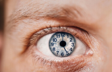 Concept of aging, time flies of man. Clock dial on eye. Close-up. Hours. minutes on the face