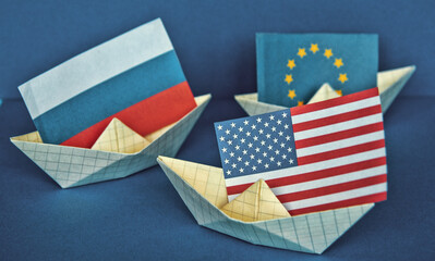 paper ship with national flag of America Usa, Russia and Europe concept of sanctions and partnerships and free trade agreement, confrontation
