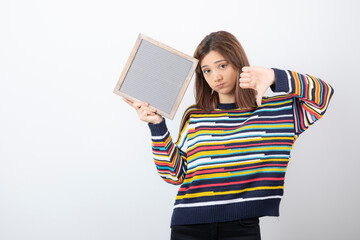 Photo of a young girl model with a frame showing a thumb down