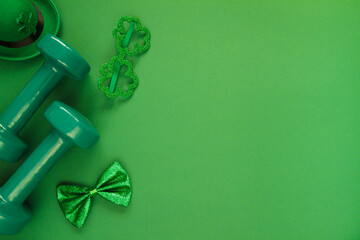 Heavy dumbbells, Irish hat with leaf clover, shamrock shape glasses and a bow tie. Healthy fitness...