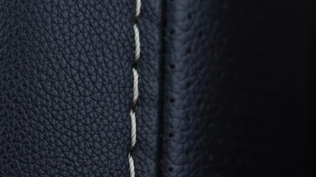 Black leather texture with seam - slow panning footage.