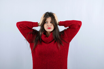 Portrait photo of a young woman model in red warm sweater standing and posing