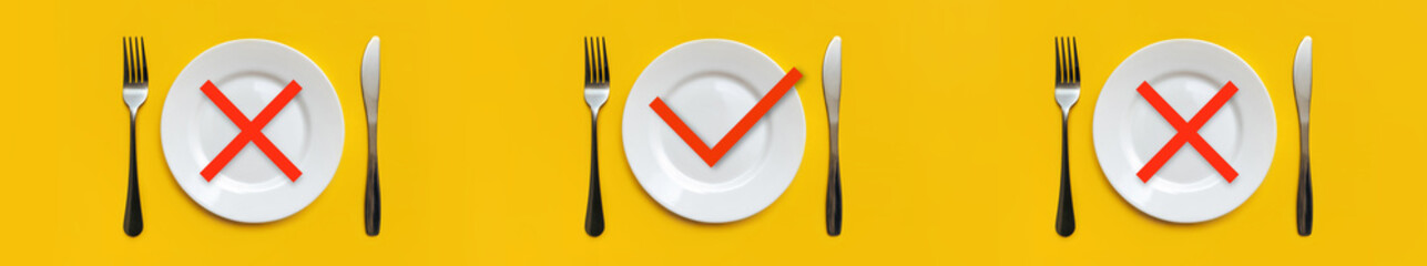 On the yellow tablecloth there are three sets of white empty plates, stainless steel forks, knives. Red crosses on place Breakfast and Dinner. A check mark - Lunch. Intermittent fasting concept, diet.