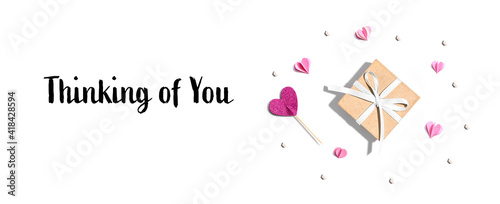 Thinking of you message with a small gift box and paper hearts