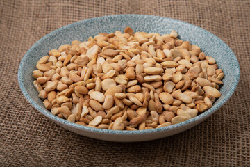 Salted crispy roasted broad beans in blue bowl on linen background