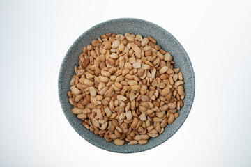 Salted crispy roasted broad beans in blue bowl on white